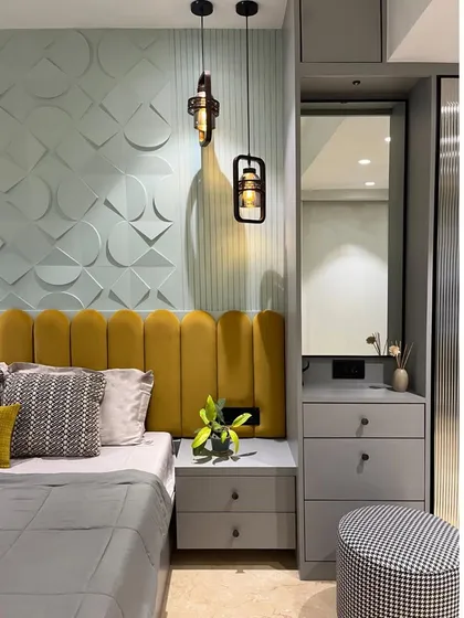 A view of the bedside and integrated dressing table. The industrial-style pendant lights add a raw, edgy element to the otherwise soft and colorful design.