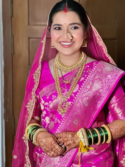 A modern Maharashtrian bride in all her glory. I loved creating this look, balancing the vibrant pink Banarasi silk with radiant skin and traditional gold jewelry for a timeless yet fresh feel.