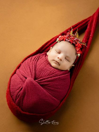 A creative hanging pose using a red sling prop. This advanced technique, taught with a focus on safety, creates a stunning and unique image.