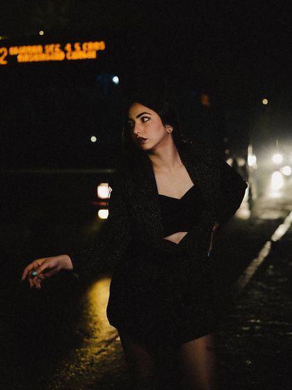 Posing against the backdrop of night traffic, using the car lights to create a cinematic effect.