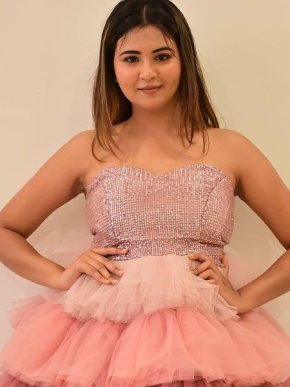 A smiling portrait of the model in her party dress.
