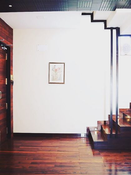 A wider view of the entrance and staircase at Overseas Traders, showing the harmony between the dark wood and white walls.