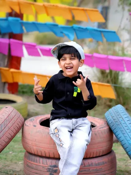 A fun and colorful outdoor setup with stacked tires and bright flags. We love creating unique and playful environments for kids to be themselves.