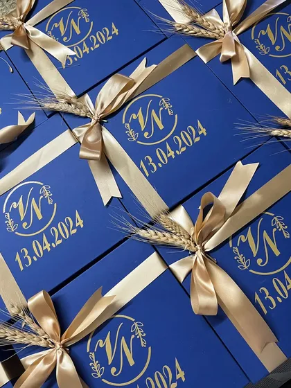 The final look of our royal blue Roka boxes, tied with a golden satin ribbon and a sprig of wheat for a traditional touch. The custom monogram and date add a beautiful, personal element.