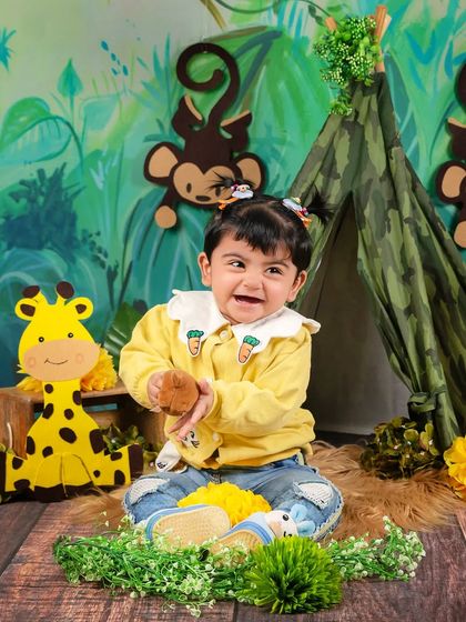 A moment of pure joy as a baby girl laughs and claps her hands in the middle of her jungle adventure setup.