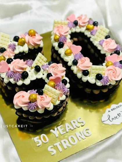 A number '50' cake for a golden anniversary. This chocolate-based cake is decorated with beautiful pink and purple buttercream flowers.