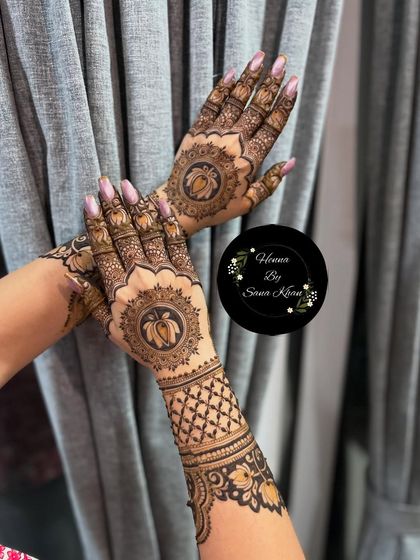 A beautiful design featuring a central lotus mandala on the back of the hand, surrounded by intricate jaali (net) work on the arm.
