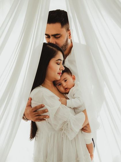 A family cocooned in love and soft white curtains. This creative framing adds an intimate, dreamy feel to this beautiful family portrait.