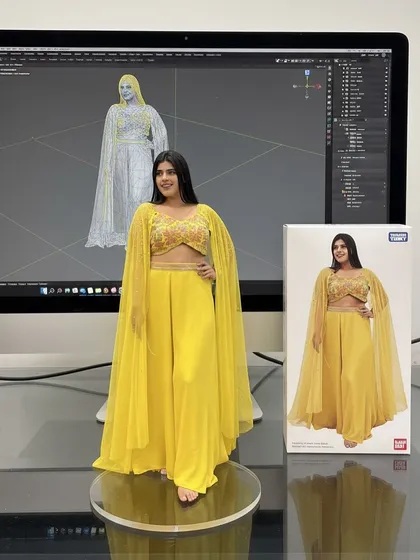 A bright yellow Indo-Western outfit with a crop top, palazzo pants, and a dramatic cape, showcased as a collectible figure.