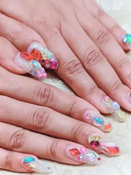 For a truly glamorous look, I created these long gel extensions adorned with an elaborate arrangement of multi-colored rhinestones, gems, and 3D elements for maximum impact.