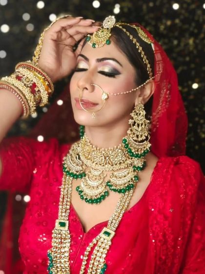 This bride showcases a classic red and green bridal jewellery combination. The layered necklaces and matching earrings are perfect for creating a grand, traditional wedding day look.