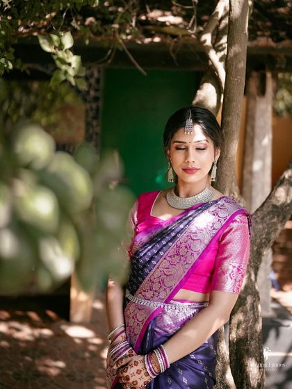 The bride with her eyes closed, a serene and contemplative moment captured in the midst of the wedding day buzz.