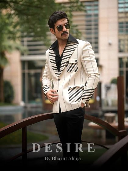 Standing tall in the white pinstripe blazer. The contrasting vertical and diagonal stripes on the pockets and lapels add a unique, modern twist to a classic pattern.
