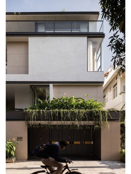 A street-level view of Villa Aish, where a cascade of greenery softens the modern facade. The design carefully crafts a private entry experience while presenting a dynamic and layered exterior to the urban environment.