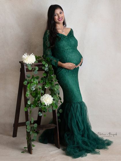 Natural elegance. The simple addition of a rustic ladder and greenery complements the emerald lace gown beautifully in this maternity portrait.