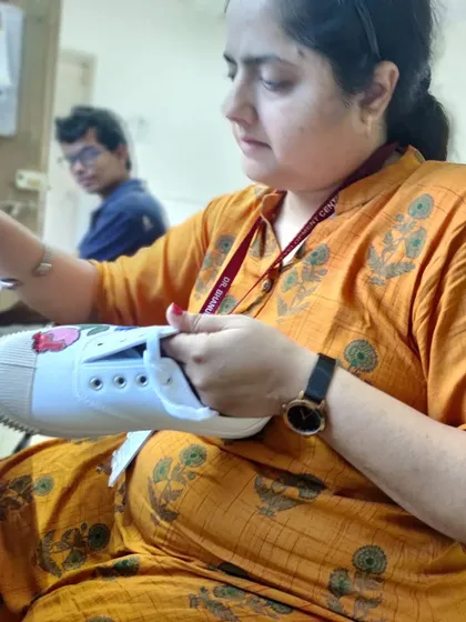 A participant fully engaged in painting her sneaker. My workshops are hands-on, providing a relaxed space where you can learn painting techniques and apply them directly to your own stuff. No experience needed.