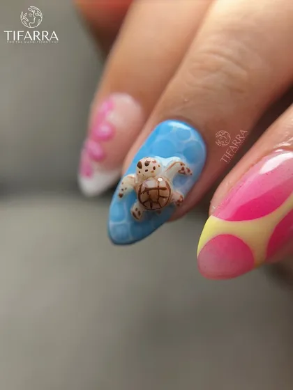 A close-up of the adorable, hand-sculpted 3D sea turtle on a blue nail with a water-ripple effect.