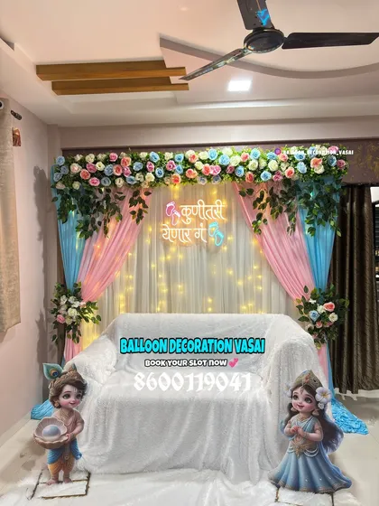 Here is a classic Dohale Jevan or Marathi baby shower decoration. The combination of pink and blue drapes, floral arrangements, and soft fairy lights creates a warm and traditional ambiance, complete with a Marathi welcome message.