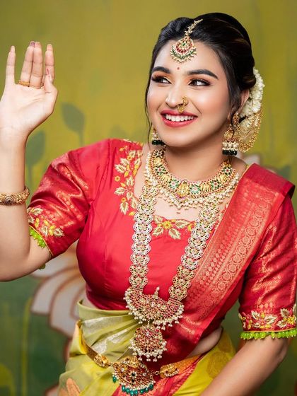Waving with a happy smile. Chitra looks stunning in the complete bridal set, showcasing how our jewellery can create a picture-perfect look.