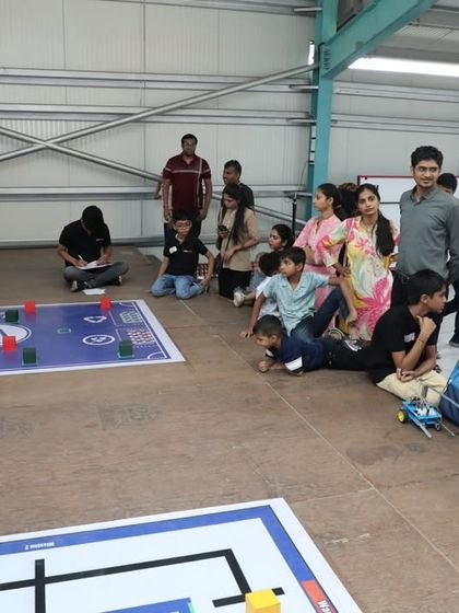 Parents and students gather around to watch a robotics competition in our workshop. We create an exciting and supportive community atmosphere where everyone can celebrate the joy of innovation.