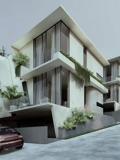 A view of the Moira Homes from the access road, showing how the structures step up the hill. The design uses angled overhangs and recessed balconies with integrated planters to create privacy and embed greenery into the architecture.