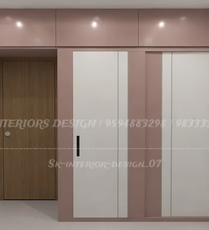A simple yet chic sliding wardrobe in a dusty rose and white combination. The black handles add a subtle contrast, and the overhead loft maximizes vertical storage.