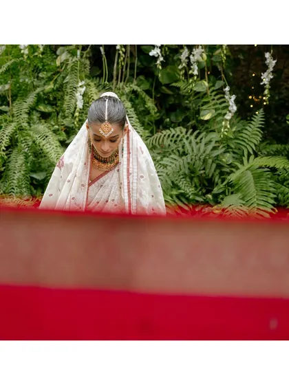 During her nikaah ceremony, Ramisa sits behind a legacy saree, a tradition that separates her from the groom. This shot, framed by the red saree, captures the quiet anticipation and cultural richness of the moment.