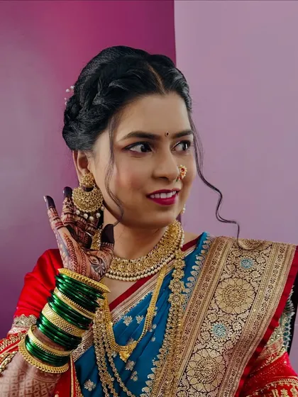 The joy of a bride on her wedding day is priceless. Her traditional look is perfected with a delicate 'nath', green bangles, and a braided hairstyle.