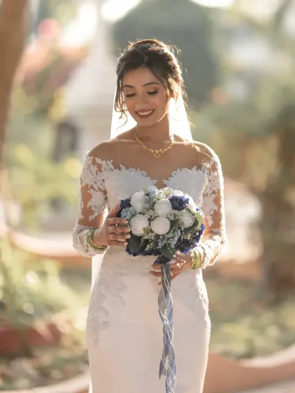 A beautiful bridal portrait with soft, flattering light. The bride's gentle smile and the focus on her bouquet create a classic and elegant image.
