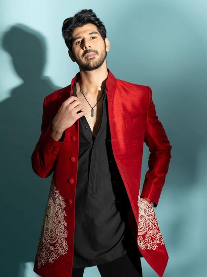 A full-length shot that displays the complete outfit, including the intricate embroidery on the jacket.