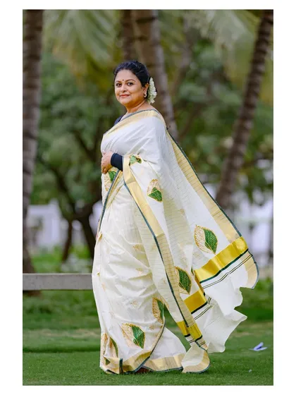 The model is captured mid-stride, showing the beautiful movement and drape of the Onam saree.