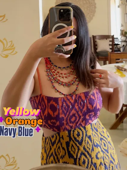 A bold and beautiful color combination of yellow, orange, and navy blue. This printed dress with a cutout detail is perfect for making a statement. The multi-colored necklace ties all the colors together.