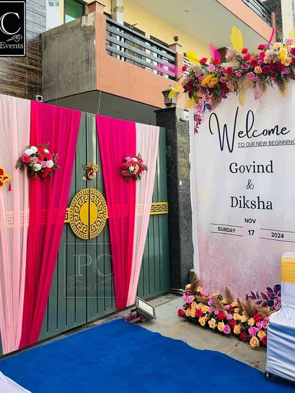 A festive welcome at the gate of the wedding house. I combined bright pink drapes with a personalized welcome banner for the couple.