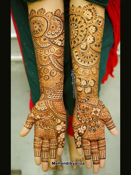 Another view of the geometric henna art, showing the beautiful flow of the design from the fingers to the arms.
