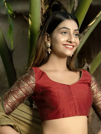 Bold in maroon, regal in gold. This full shot shows how the stunning brocade sleeves complement the simple, elegant cut of the blouse, creating a perfectly balanced festive look.