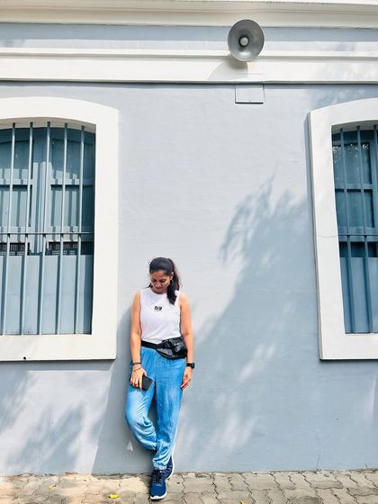 A traveler posing against the iconic blue and white walls of the French Quarter in Pondicherry.