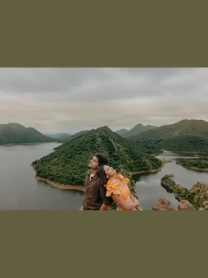 A moment of peaceful rest overlooking the serene lakes and hills of Udaipur. This destination pre-wedding shot captures the tranquility of the landscape.