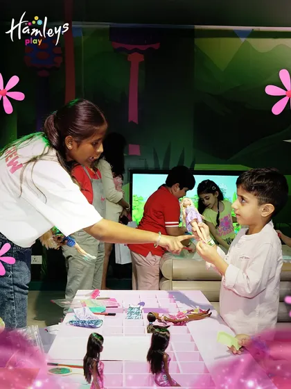 During our Barbie-themed party, every child gets to play and create. A Play Pal is seen here helping a young boy choose a doll for a styling session at our pop-up Barbie Style Studio.