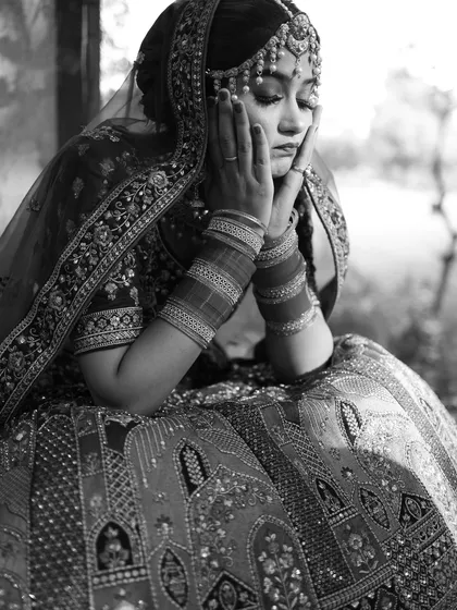 A pensive, black and white portrait of the bride. This shot captures a moment of quiet contemplation before the ceremony, highlighting the emotional depth of the day.