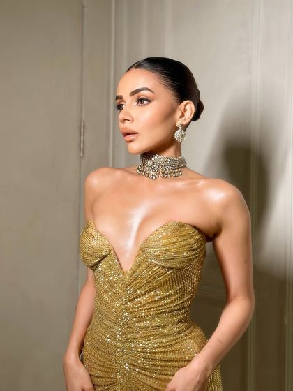 A side profile showing the sleek bun and the beautiful highlight on the cheekbones.