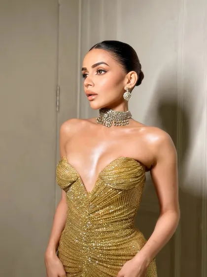 A side profile showing the sleek bun and the beautiful highlight on the cheekbones.