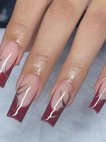 A dramatic design with deep red French tips and sharp, abstract silver line art.