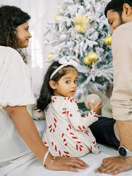 A little girl gives a curious look over her shoulder. The candid moments during a holiday session are often the most charming.