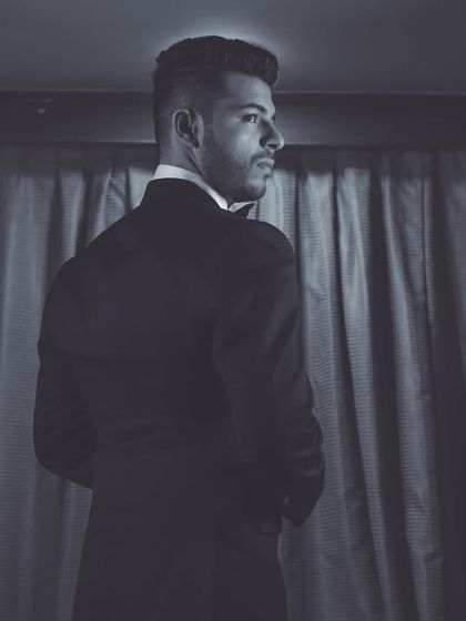 A black and white portrait of the groom looking away, creating a classic and contemplative mood.