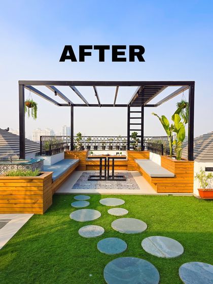 A bright, sunny "after" view of the terrace with the wooden pergola seating. The combination of natural wood tones, green lawn, and blue sky creates a fresh and inviting atmosphere.