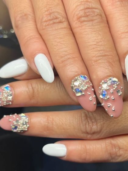 A bold and beautiful set combining crisp white nails with nude accent nails covered in stunning blue and silver 3D rhinestone clusters.