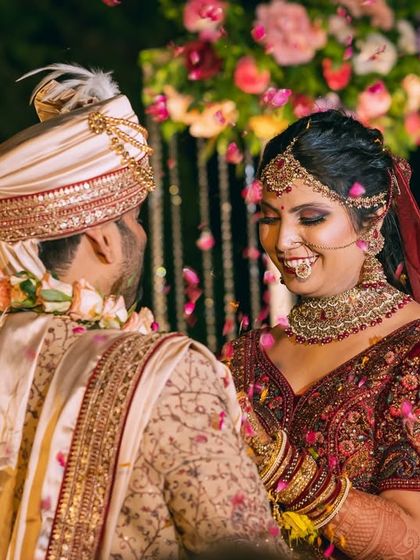 A beautiful, happy moment between the couple under a shower of rose petals, capturing their smiles and connection.