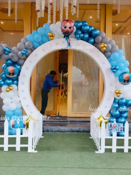 We create unique entrances like this circular arch decorated with blue, silver, and white balloons for a modern take on the Boss Baby party theme.
