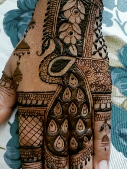 A close-up of a bold peacock motif, a classic element in mehendi art, designed with a modern Arabic touch.
