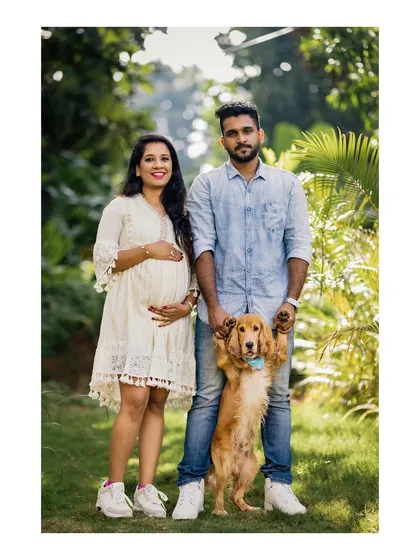 A beautiful family portrait of an expecting couple with their beloved dog, who stands proudly between them. This image shows our love for including furry family members in your most important memories.